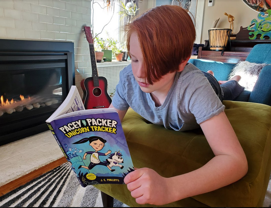 Boy reads Pacey Packer Unicorn Tracker